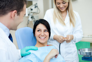 young female patient in dental chair talking to dentist, Sarasota, FL tooth extractions